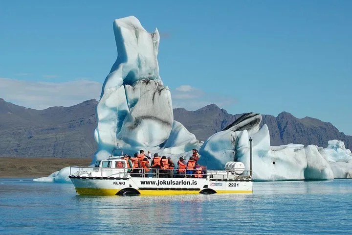 Boat cruising between drifting icebergs on a Jökulsárlón glacier lagoon boat tour in South East Iceland
