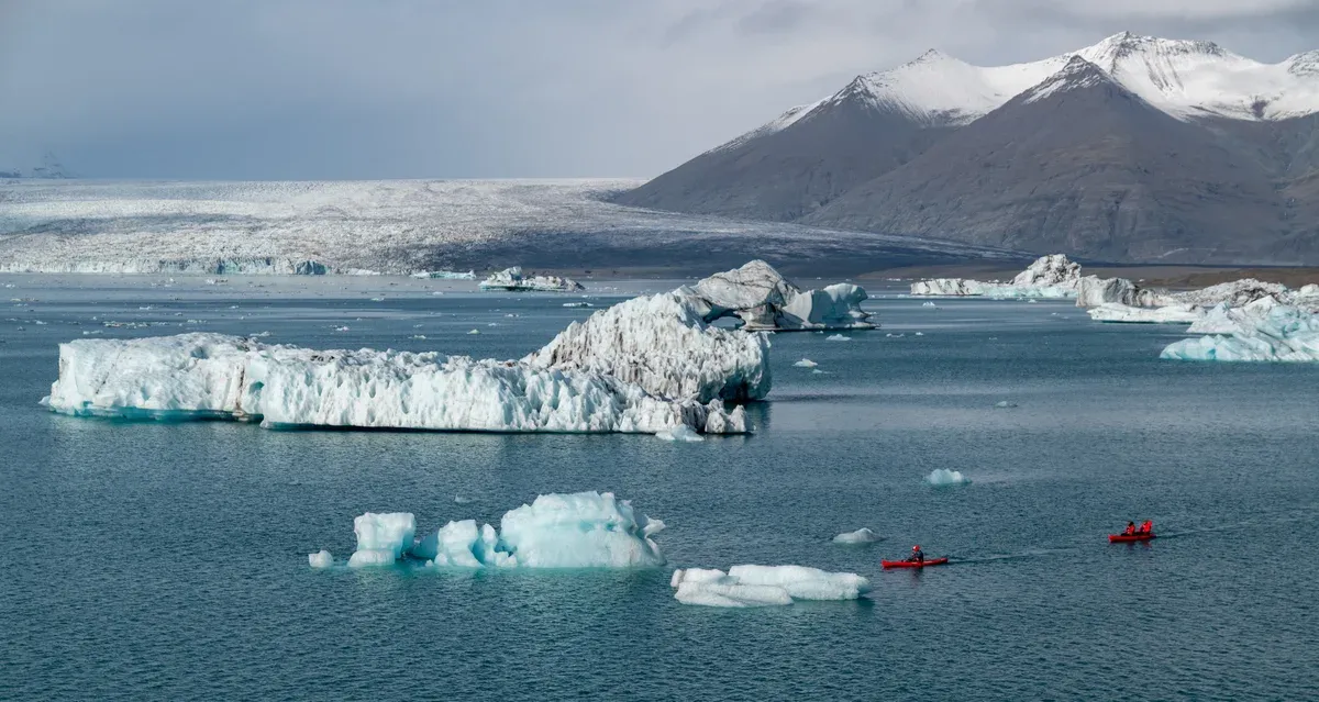 Red boats among icebergs on Jökulsárlón during a glacier lagoon boat tour
