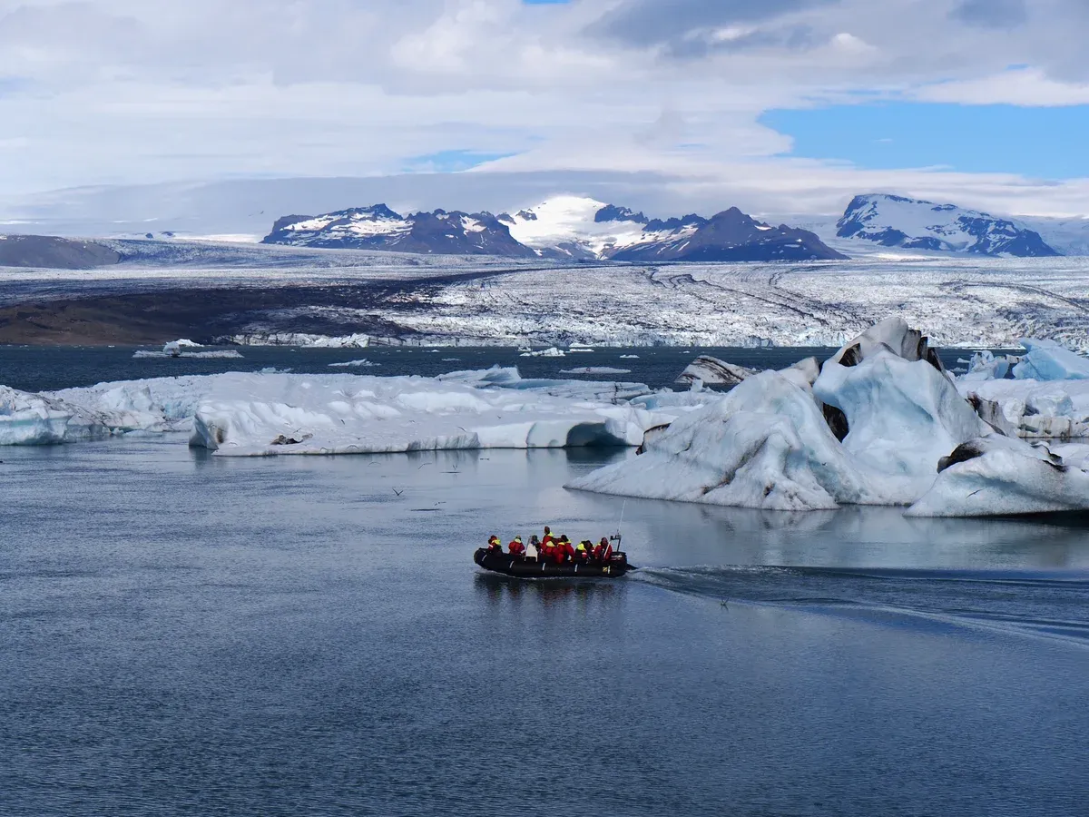 A Zodiac crossing the lagoon toward the Breiðamerkurjökull glacier tongue on a Jökulsárlón glacier lagoon boat tour